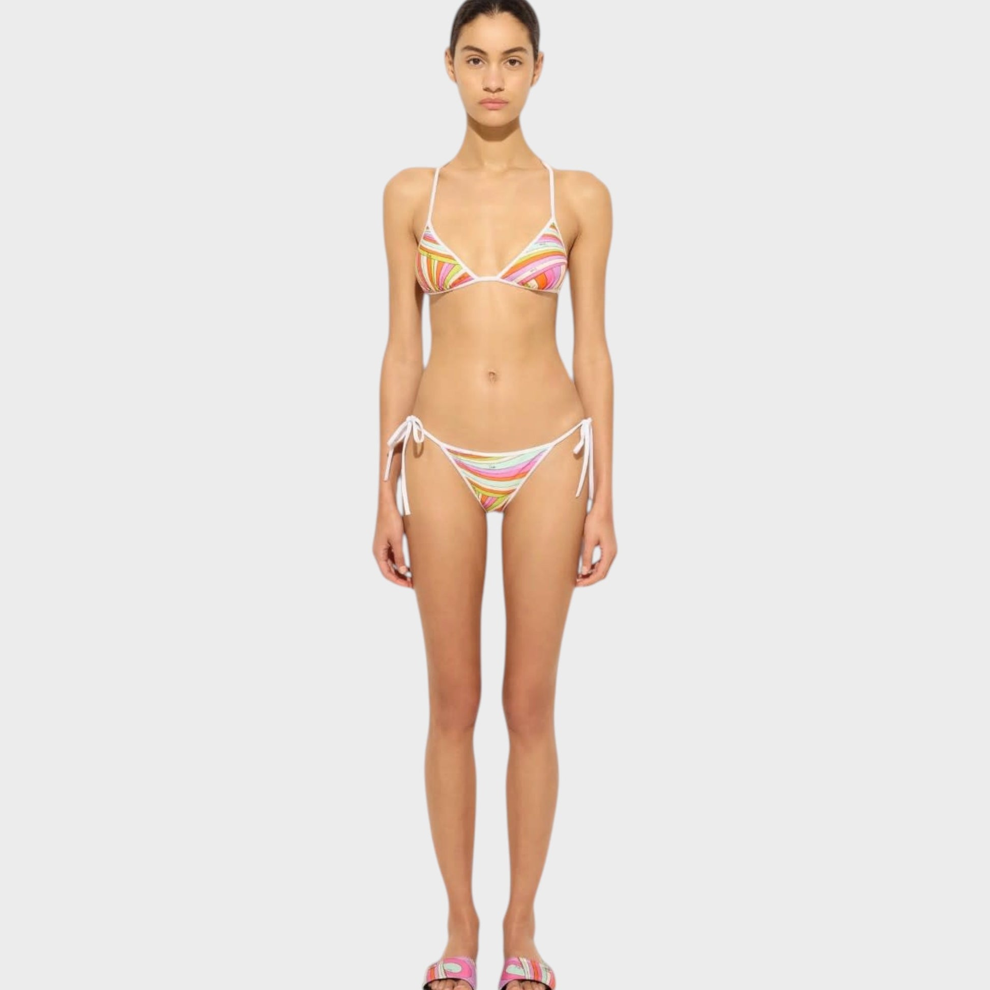 Model wearing a Tasoni Pucci triangle bikini top with a colorful abstract print and white tie-side bikini bottoms.
