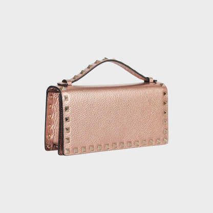 Tasoni rose gold metallic leather clutch with signature pyramid studs and top handle.