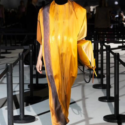 Tasoni Marie Adam-Leenaerdt silk satin sunset landscape print dress in light orange with dark brown vertical stripes.