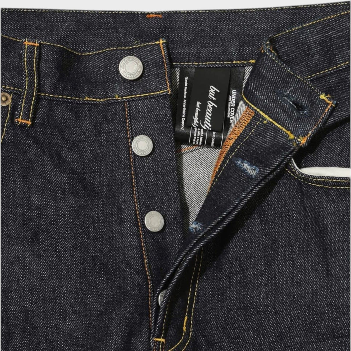 Tasoni x Undercover blue denim wide leg pants with embroidered poem detail and button fly.