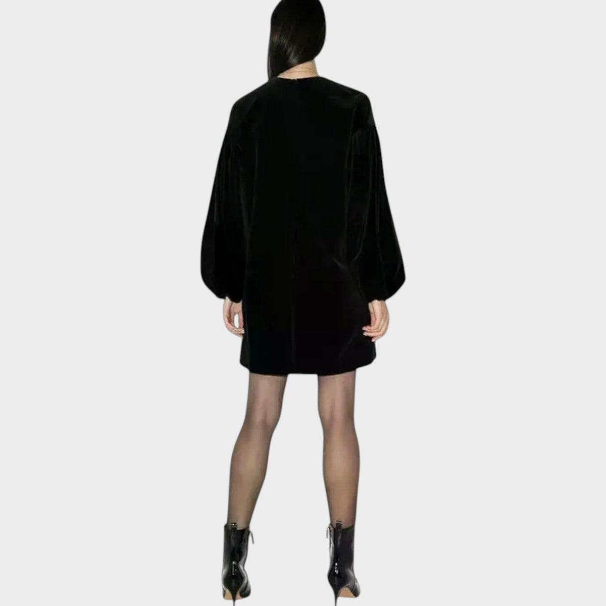 Back view of a model wearing a black Tasoni Valentino velvet balloon mini dress with long sleeves.