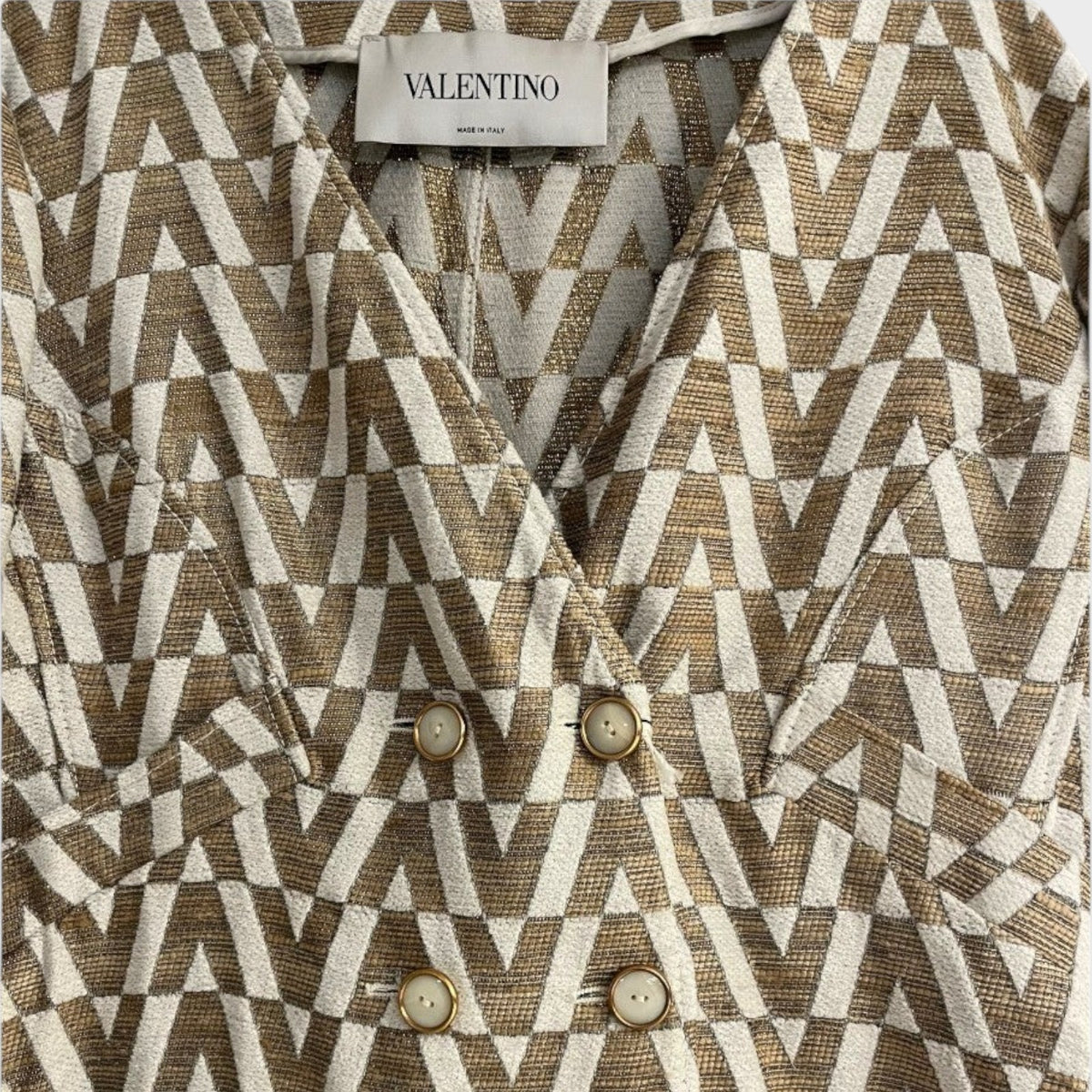 Tasoni Valentino brocade coat featuring a tan and white geometric V logo pattern with double-breasted button closure.
