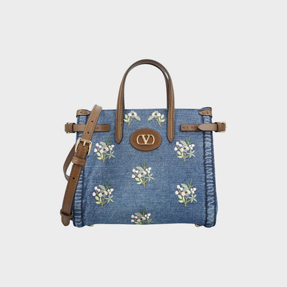 Tasoni Valentino small denim tote bag with multicolor floral embroidery and brown leather trim and straps.