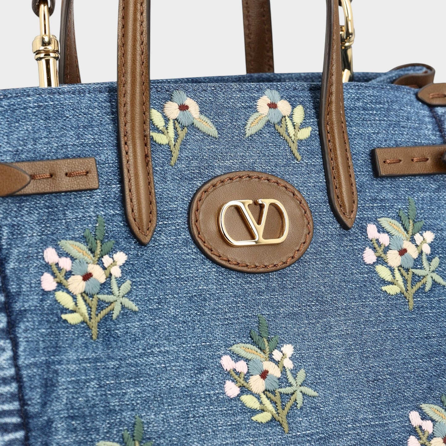 Tasoni Valentino small denim tote bag with multicolor floral embroidery and brown leather trim.