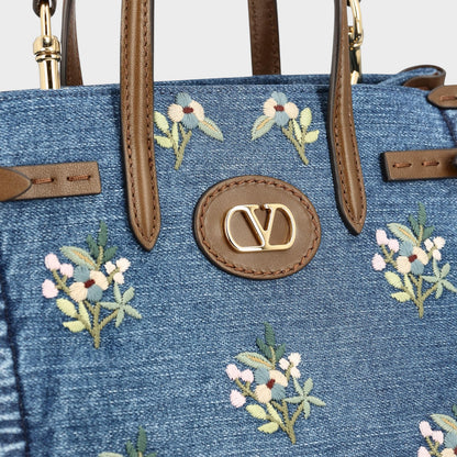 Tasoni Valentino small denim tote bag with multicolor floral embroidery and brown leather trim.