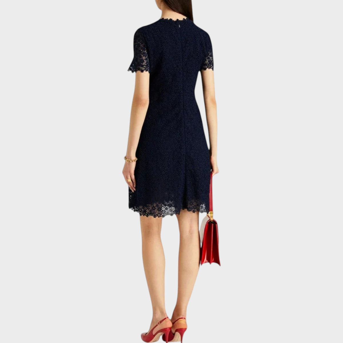 Tasoni Valentino L'Amour navy blue lace dress with short sleeves, worn with red heels and a matching red handbag.