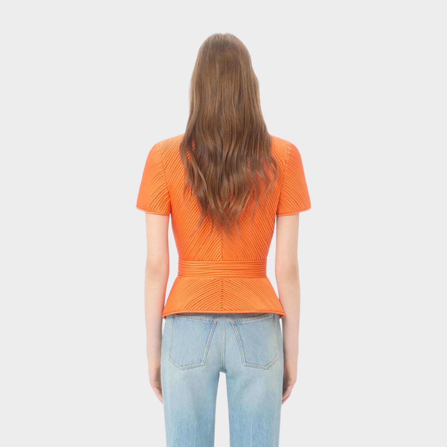 Tasoni Valentino short sleeve jacket in dirty orange with pleated detail and belted waist. Worn by a model with light wash jeans.