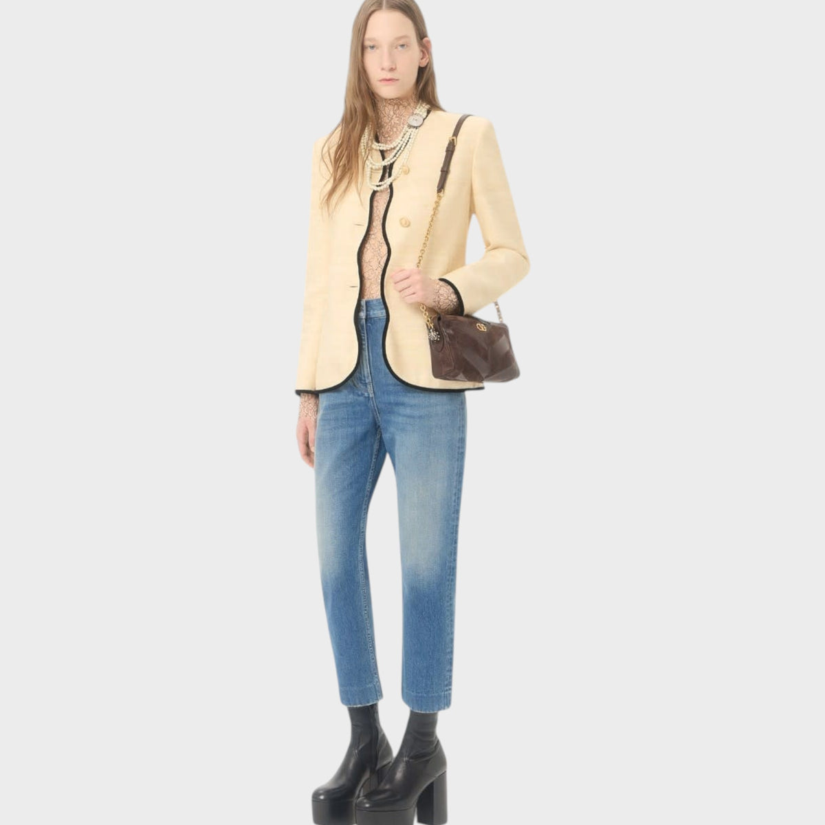 Model wearing Tasoni Valentino Panthea small shoulder bag in ebony and oak brown with a cream blazer and blue jeans.