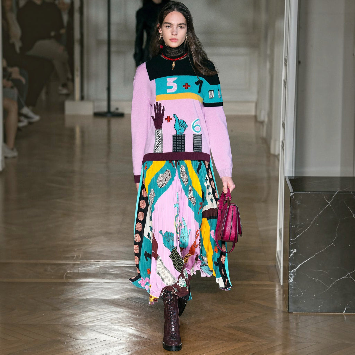 Model wearing a Tasoni Valentino crepe de chine pleated skirt with a vibrant multi-coloured graphic print