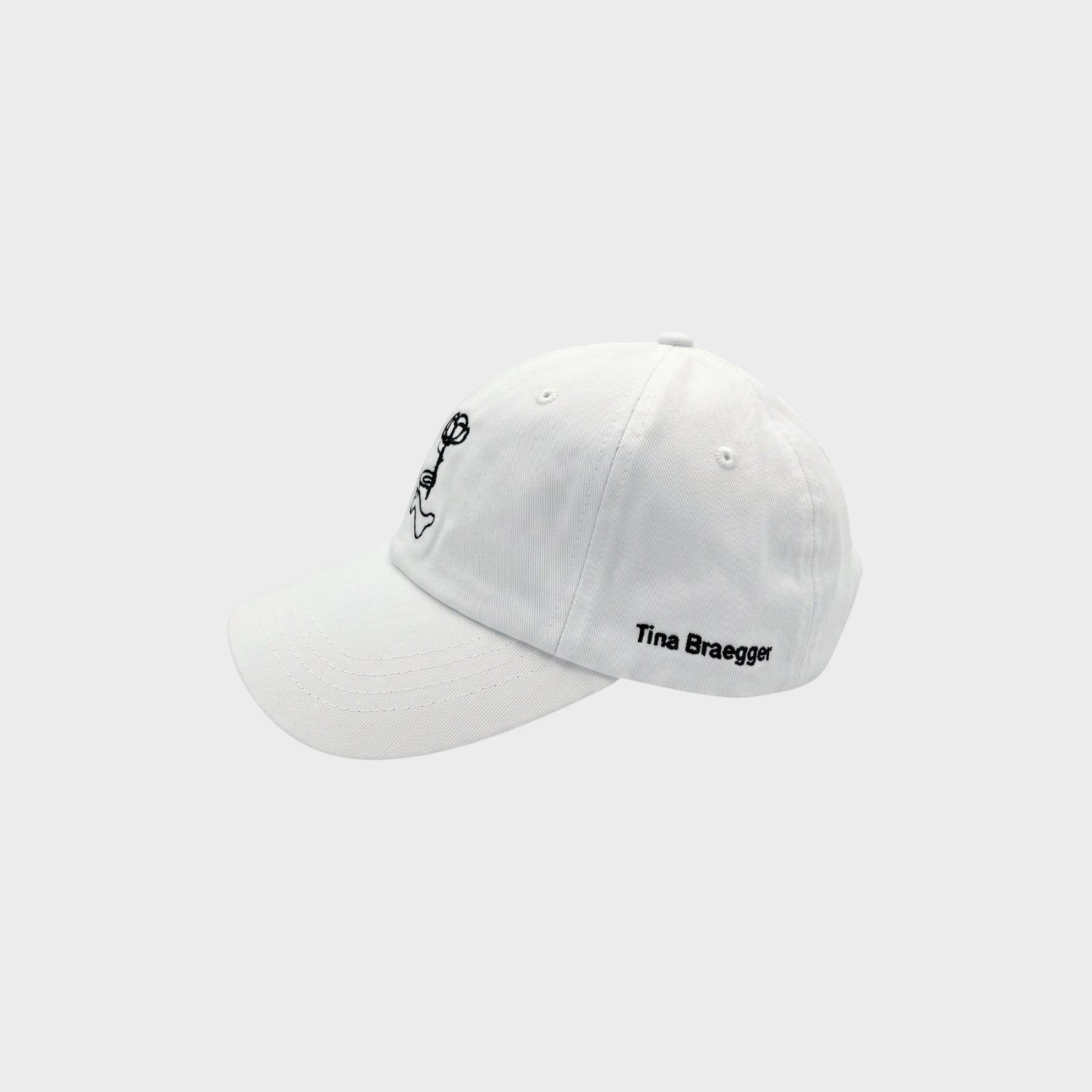 Tasoni white cotton baseball cap with bear embroidery and Tina Braegger signature.