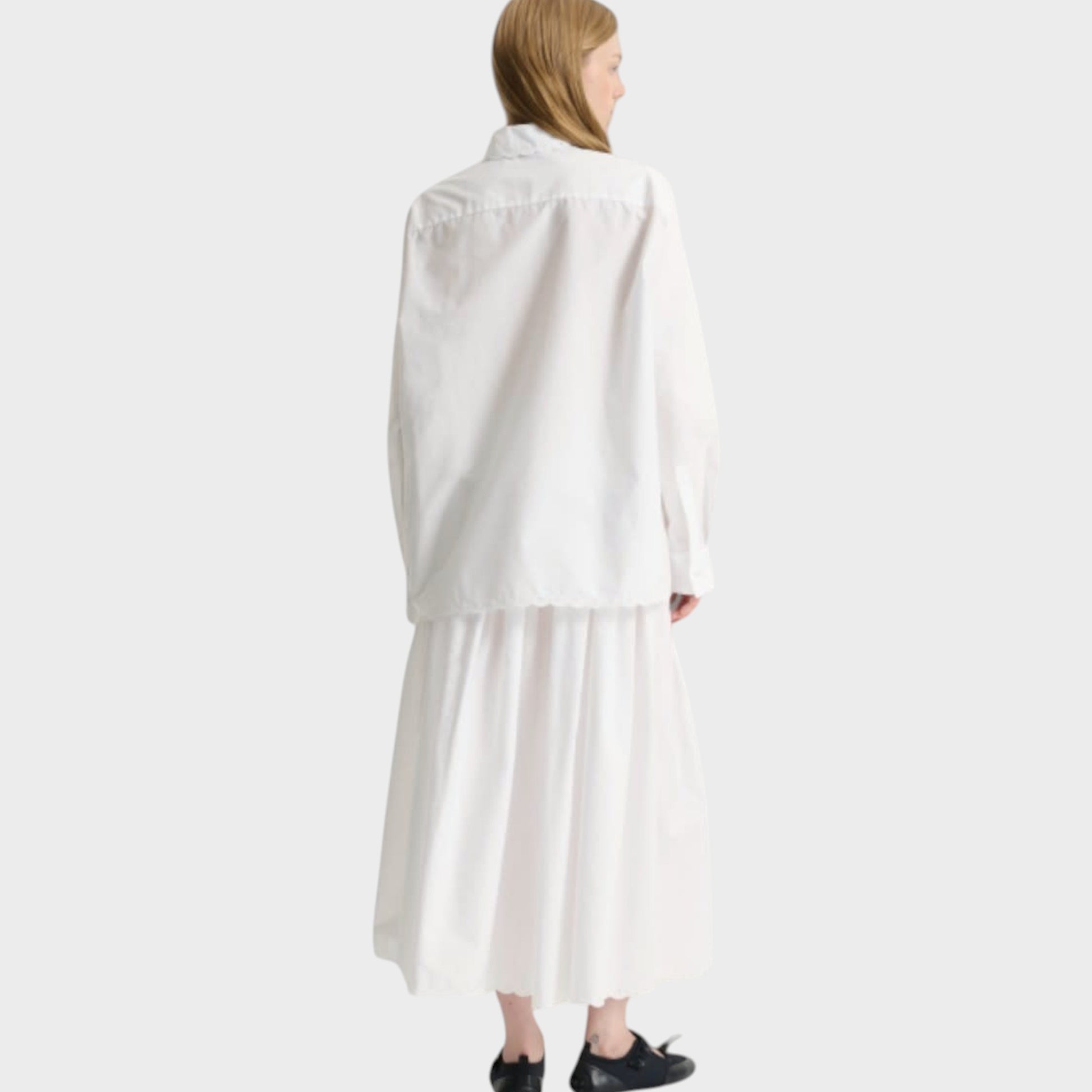 Tasoni white broderie anglaise cotton shirt with button front and long sleeves, paired with a white midi skirt.