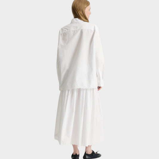 Tasoni white broderie anglaise cotton shirt with button front and long sleeves, paired with a white midi skirt.