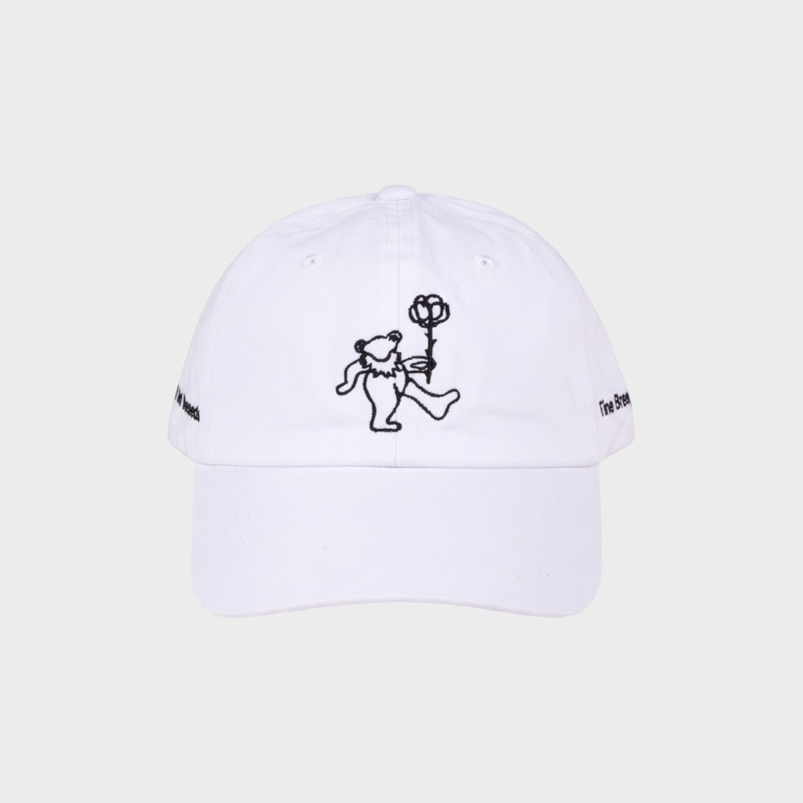 Tasoni x Tina Braegger white baseball cap with embroidered dancing bear holding a rose and text on sides.