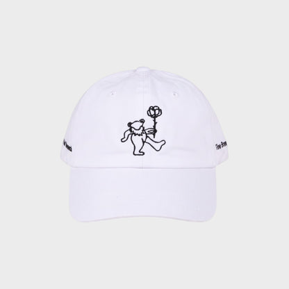 Tasoni x Tina Braegger white baseball cap with embroidered dancing bear holding a rose and text on sides.