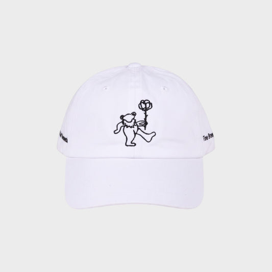 Tasoni x Tina Braegger white baseball cap with embroidered dancing bear holding a rose and text on sides.