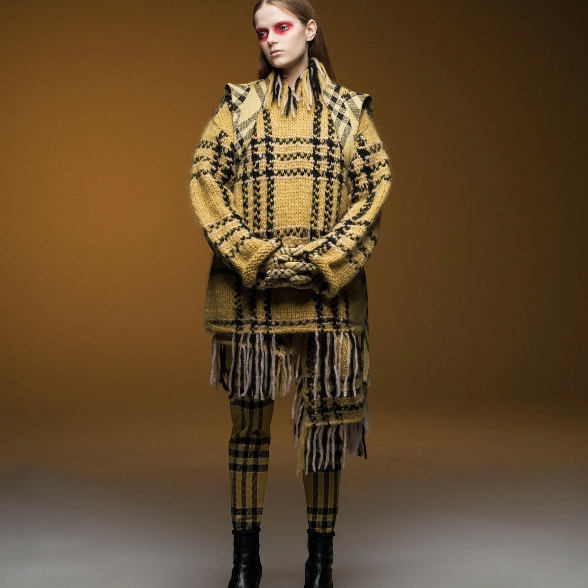 Tasoni yellow and black wool check elastic waist trousers with fringe detail and matching sweater. Model wears black boots.