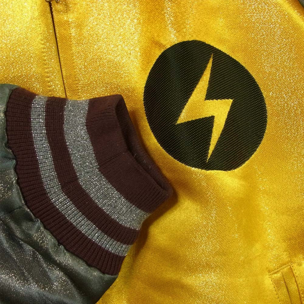 Tasoni yellow bomber jacket with lightning bolt graphic and striped cuffs.