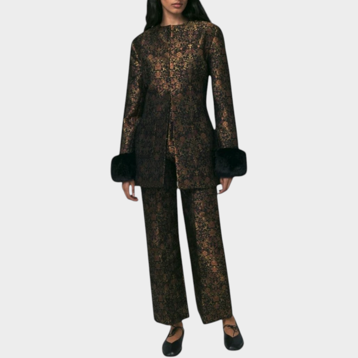 Tasoni model wearing a Destree Lea Garden structured jacket and matching trousers in black and gold floral brocade.